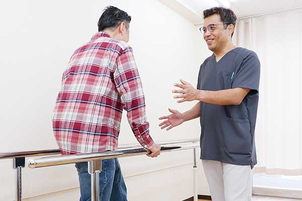 平行棒の運動を行う患者様の画像