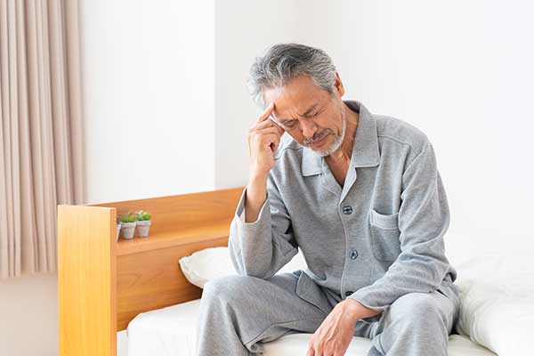寝起きの不調に悩む男性のイメージ画像